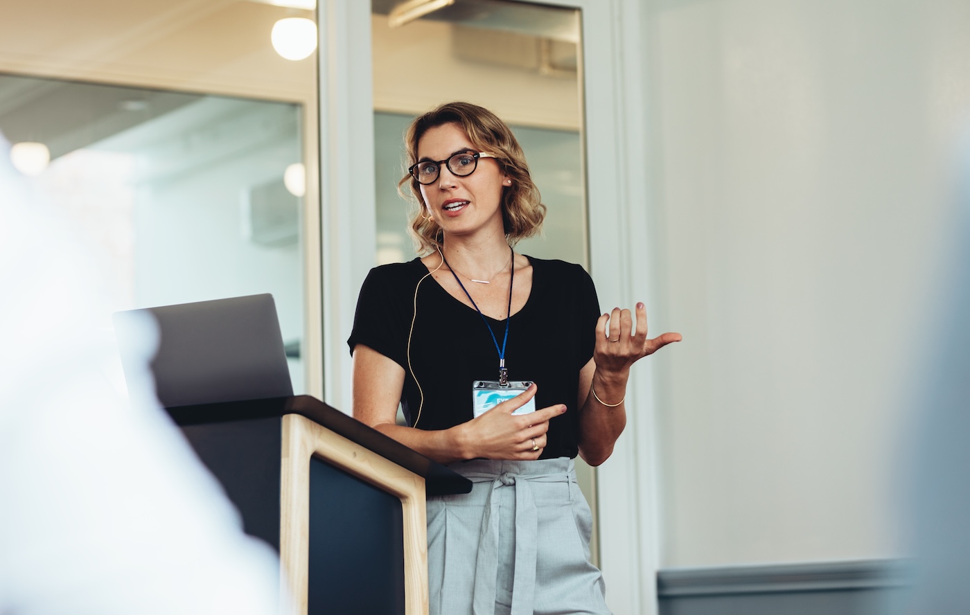 Businesswoman delivering a speech during a conference. Female entrepreneur explaining new project in a conference.